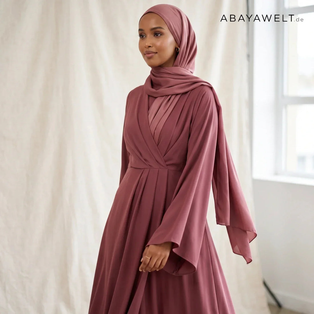 Frau in fließender rosa Nida-Abaya mit rosa Hijab