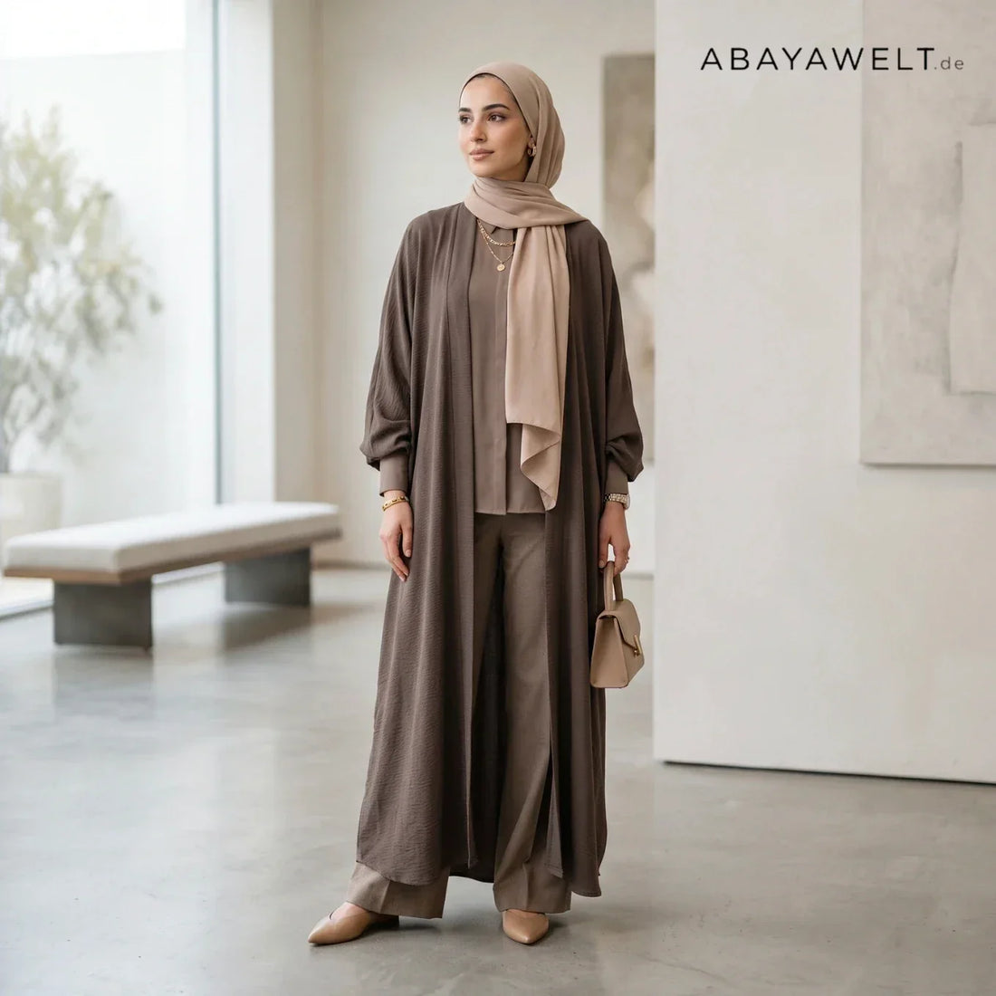 Frau mit offener brauner Abaya, beigem Hijab und weiter Hose